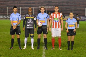 Árbitro Ramon Abatti Abel, que já jogou nas categoria de base do Hercílio, com os auxiliares Alexandre Medeiros Lodetti e Elen Carolin Portal Sieglitz e os capitães Eydison, do Brusque, e Daniel, do Hercílio Luz. (Foto: Lucas Gabriel Cardoso)