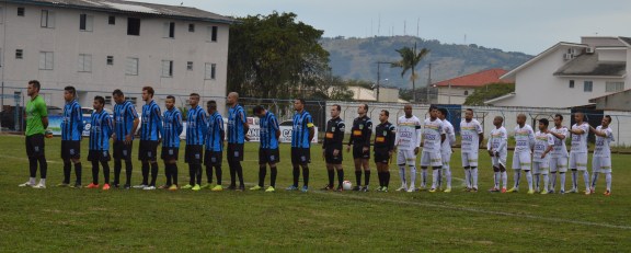 Atlético Tubarão (Enderson; Mota, Ianson, Celso e Cleiton; Xipote, Daniel, Esquerdinha e Dionísio; Pablo e Régis) e Brusque (Wanderson; João Neto, Rogélio, Cleyton e Flavinho; Mineiro, Wendel, Paulinho e Wellington Simião; Eydison e Tony) perfilados para os hinos do Brasil e de Senta Catarina. (Foto: Lucas Gabriel Cardoso)