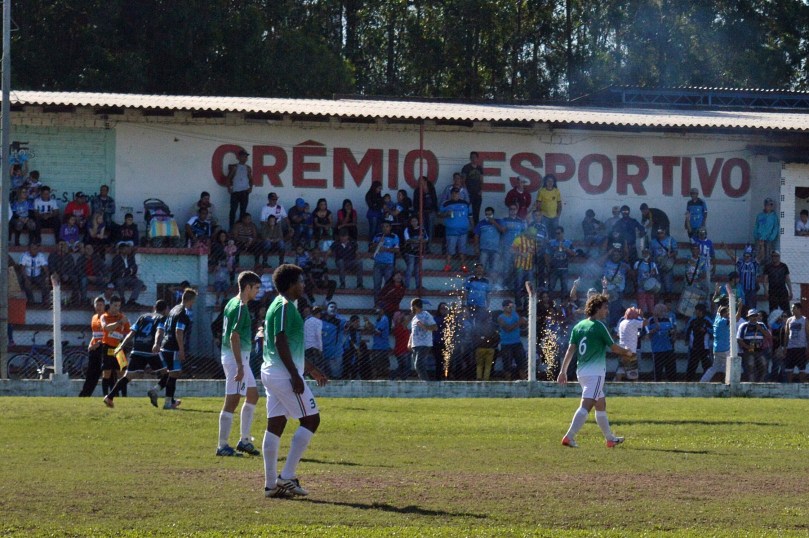 Enquanto os jogadores do Papagaio lamentavam a falha na marcação, Alan Machado e seus companheiros comemoravam junto à torcida e suas pirotecnias. (Foto: Lucas Gabriel Cardoso)